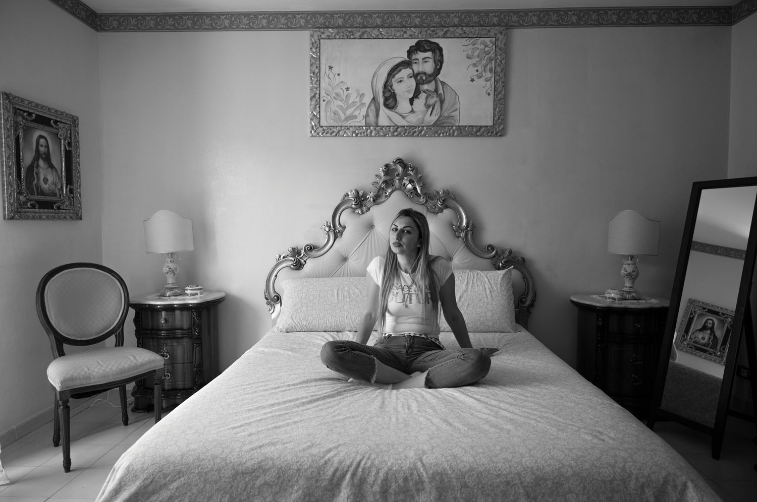 Agata Di Bella sitting on her bed cross legged. May 2022.