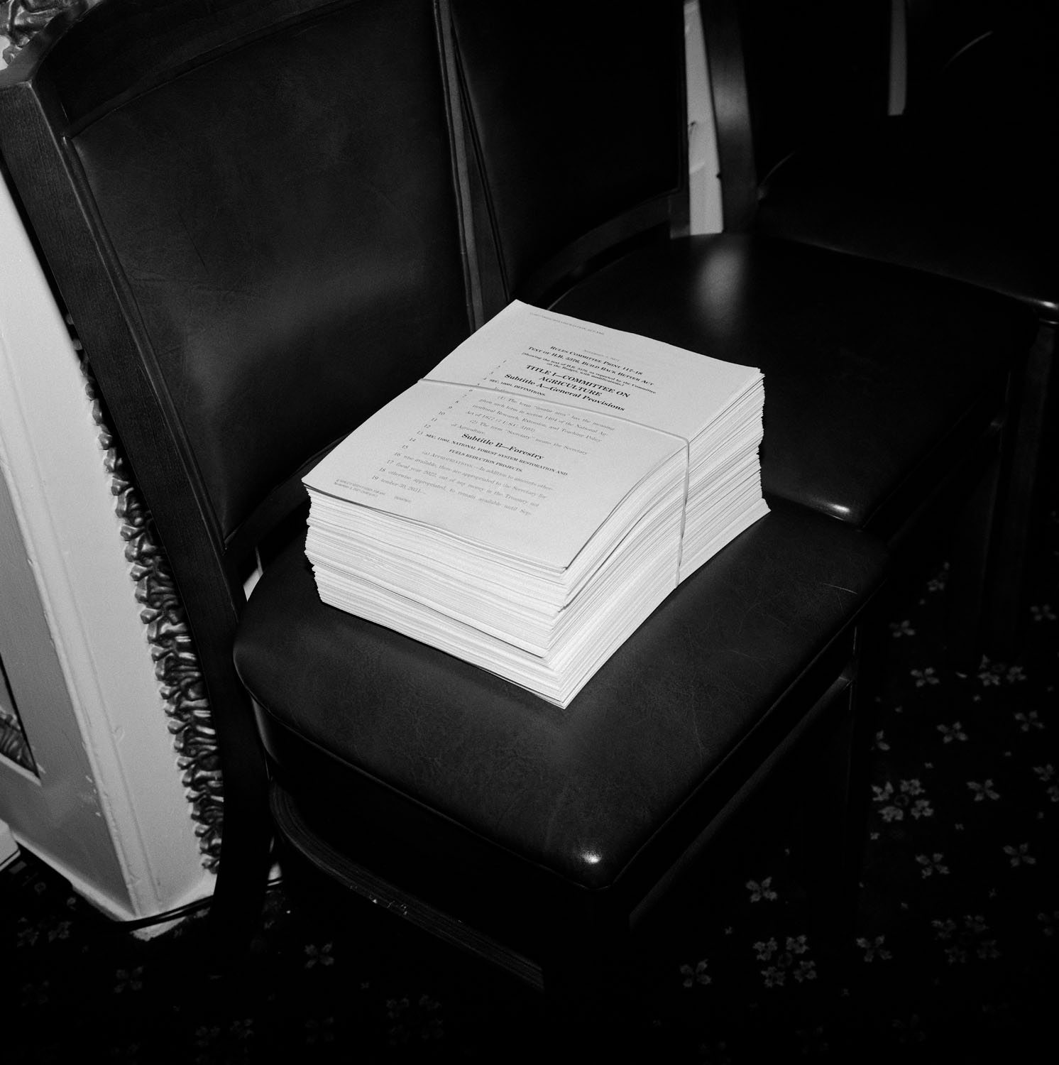 Stack of papers on chair.