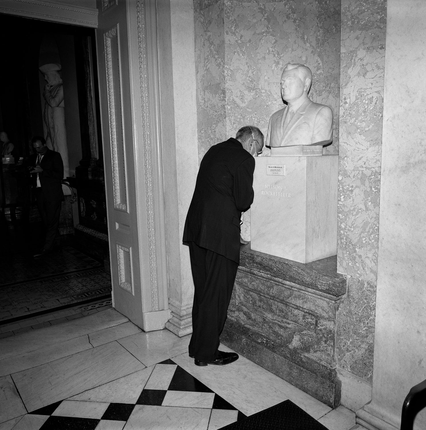 Man bends over bust. 