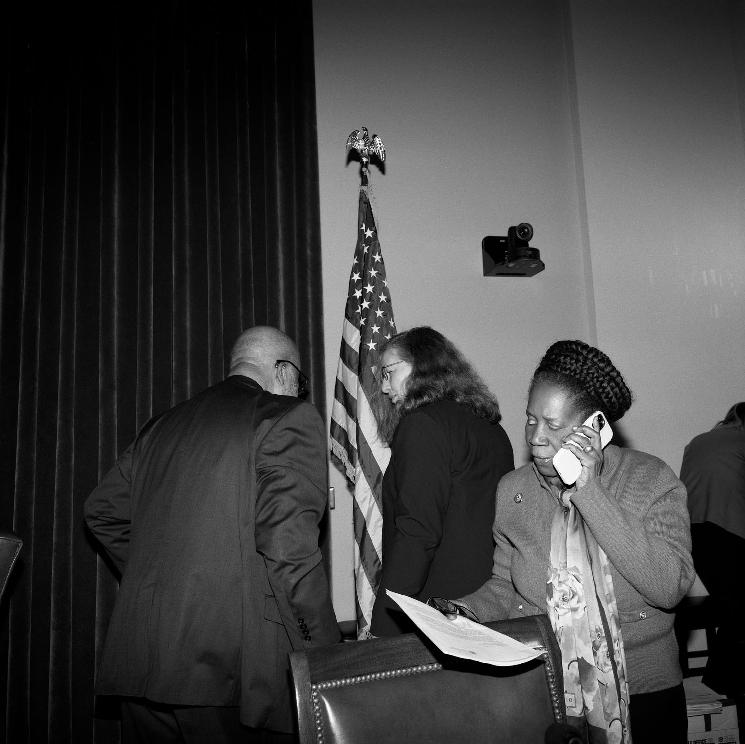 Woman takes phone call and holds papers.