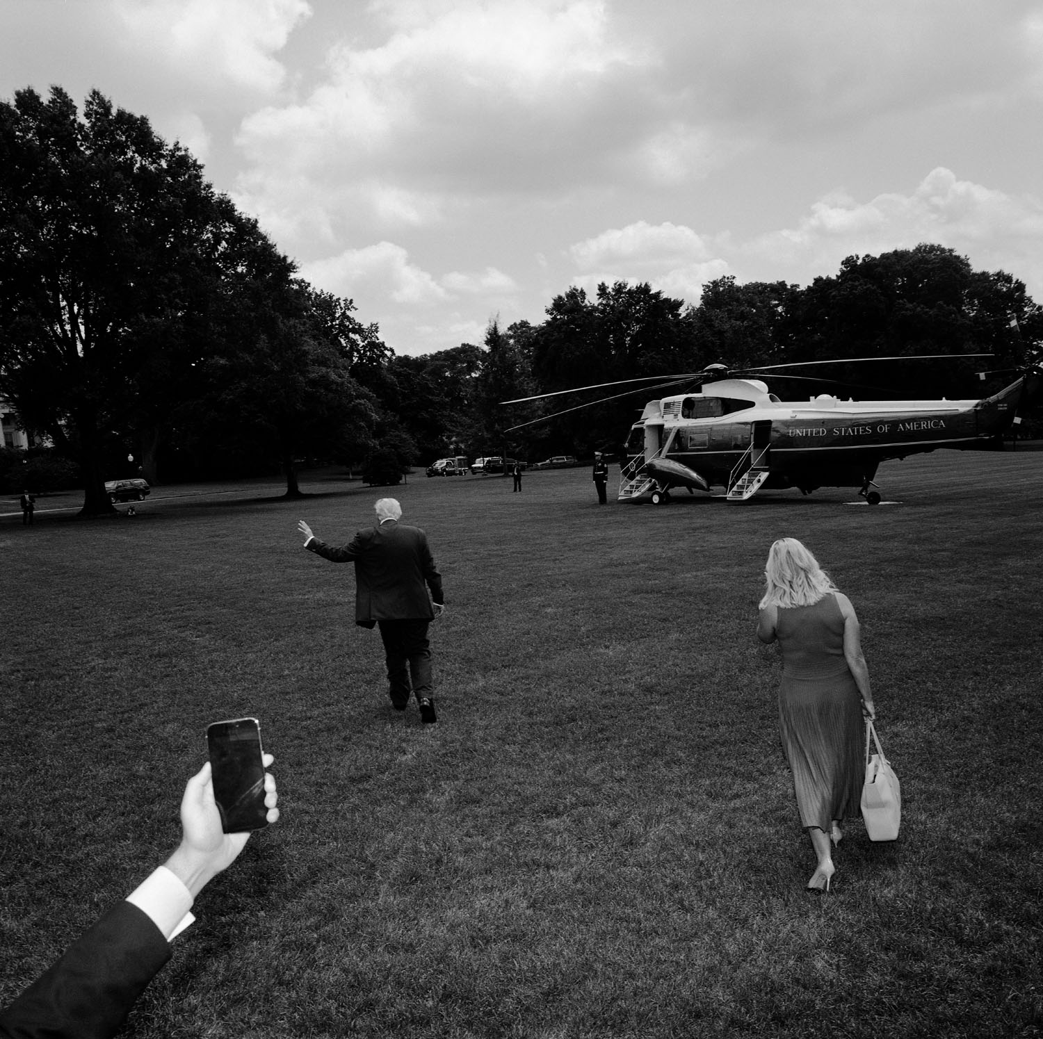 Trump and Leavitt walk on field towards airplane.