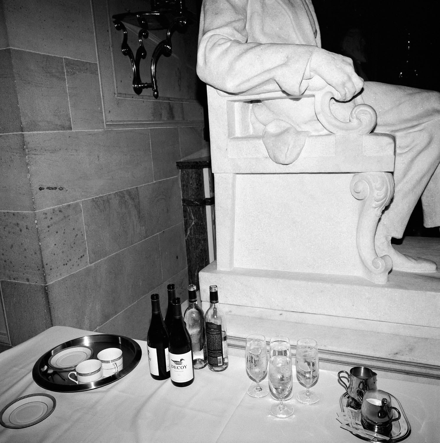 Drinks sit on table by statue.