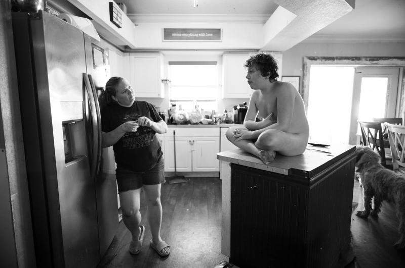 Boy sits on counter with no clothes on.