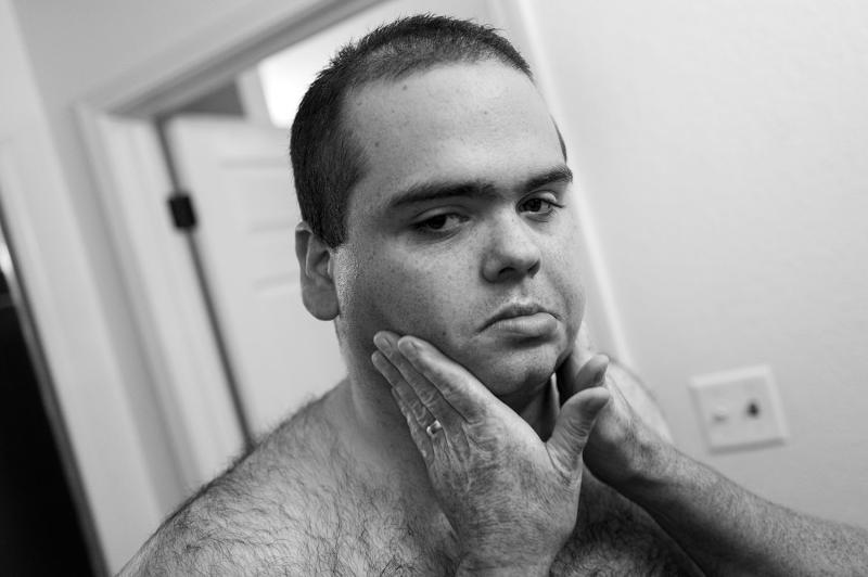 Boy frowns; hands hold his face.