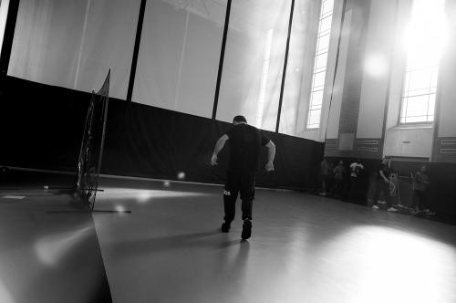 Boy stands on gymnasium floor. 