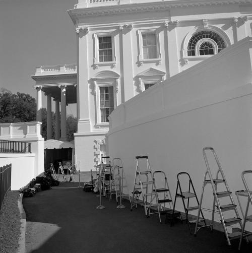 Ladders set up by wall.