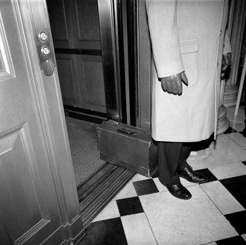 Briefcase on floor by man. 